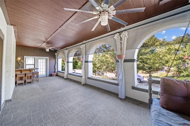 unfurnished sunroom with wooden ceiling and ceiling fan