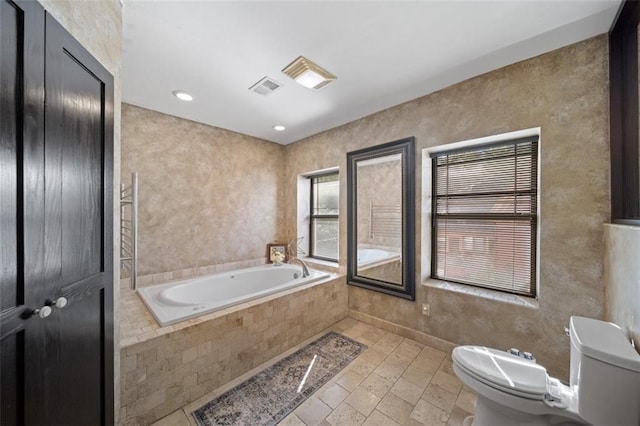 bathroom with a bidet, a relaxing tiled tub, and toilet