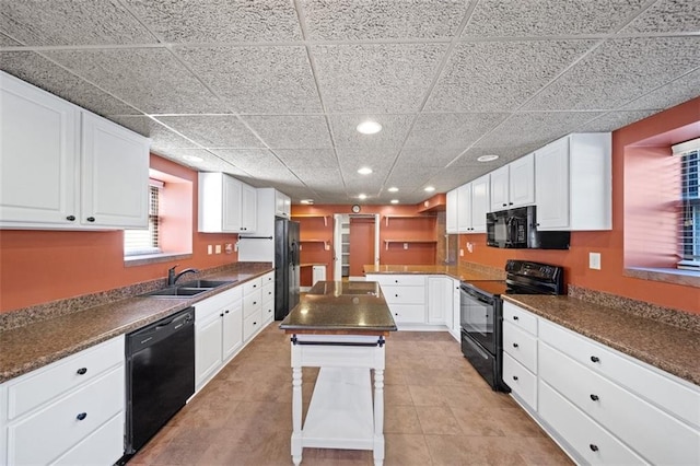 kitchen featuring white cabinetry, a kitchen island, sink, and black appliances