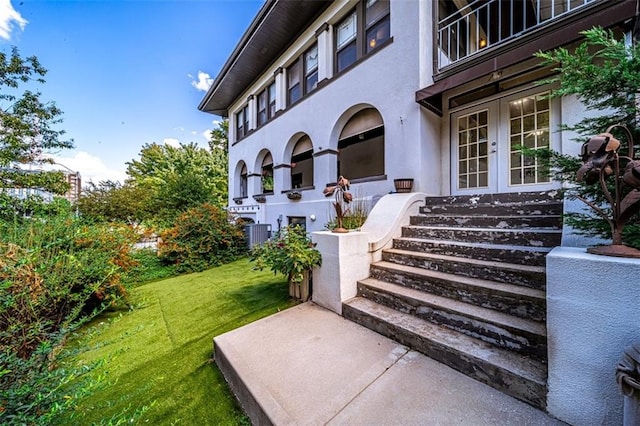 doorway to property featuring a lawn and french doors