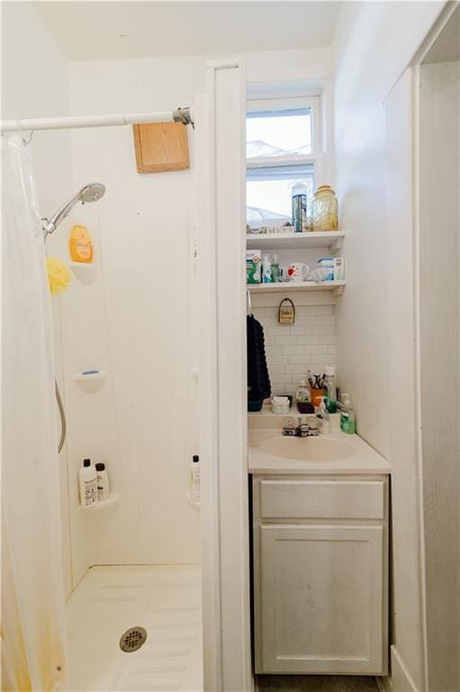 bathroom featuring vanity, backsplash, and curtained shower