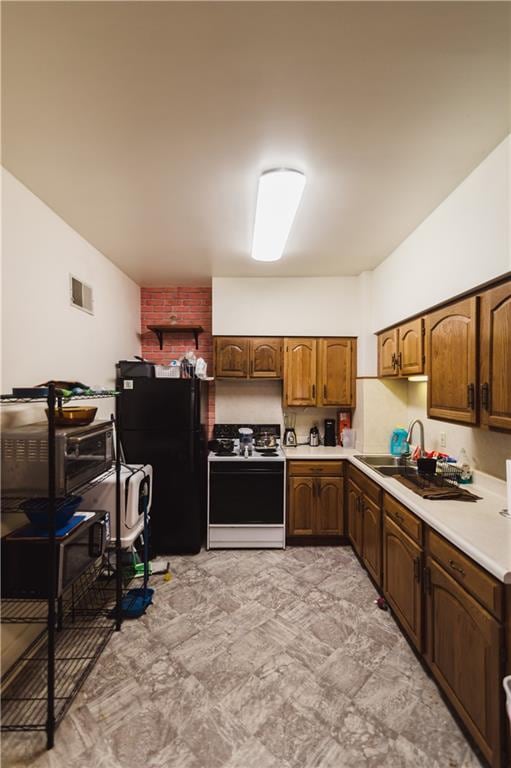 kitchen with white range, black fridge, and sink