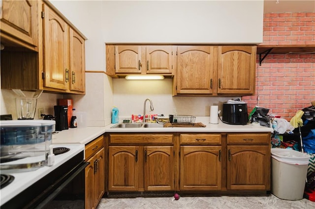 kitchen with brick wall, sink, and white range oven