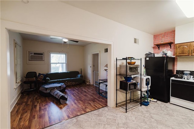 exercise room with ceiling fan, light hardwood / wood-style flooring, and a wall unit AC