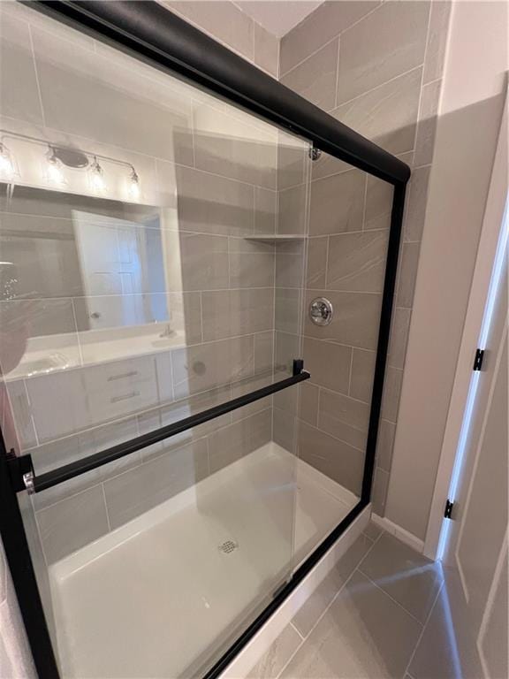 bathroom with tile patterned flooring and a shower with shower door