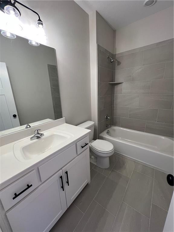 full bathroom with tile patterned floors, vanity, toilet, and tiled shower / bath