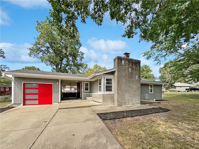 view of front facade featuring a garage, a carport, and a front lawn