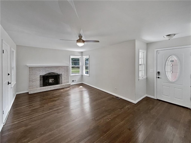 foyer entrance with a fireplace, dark hardwood / wood-style floors, and ceiling fan