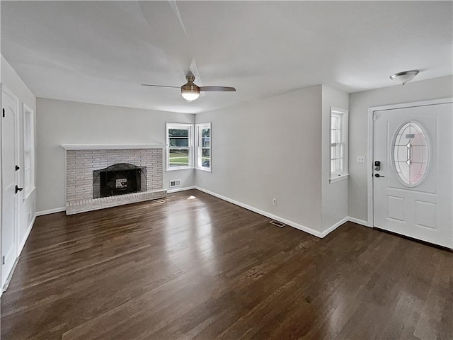 entryway featuring ceiling fan, a fireplace, and dark hardwood / wood-style flooring