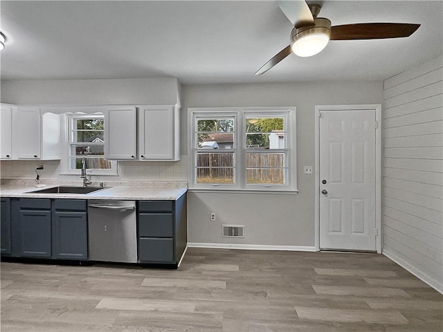 kitchen with light hardwood / wood-style flooring, white cabinets, ceiling fan, and stainless steel dishwasher