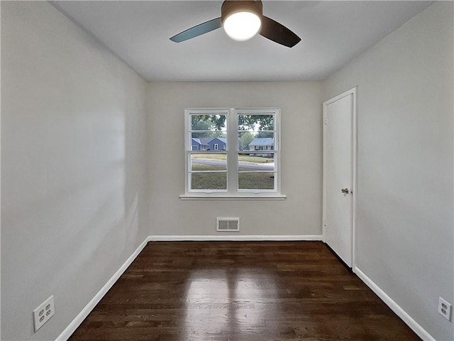 spare room featuring dark hardwood / wood-style flooring and ceiling fan