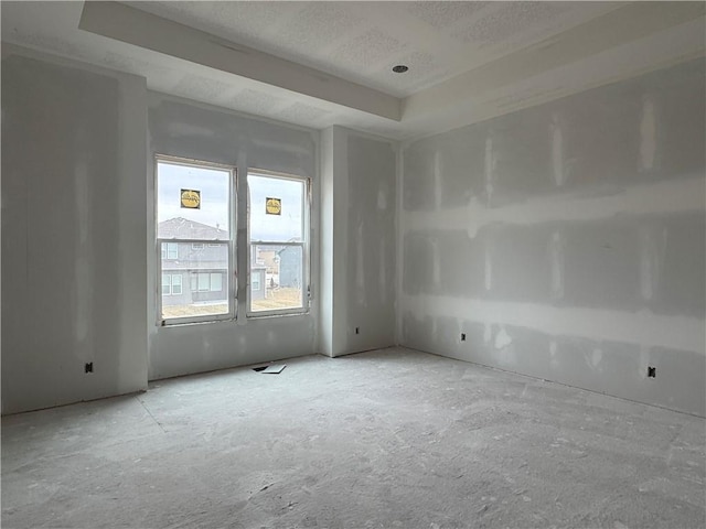 unfurnished room featuring a tray ceiling