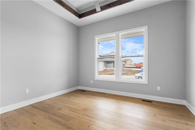 spare room with light wood-style floors, baseboards, and visible vents