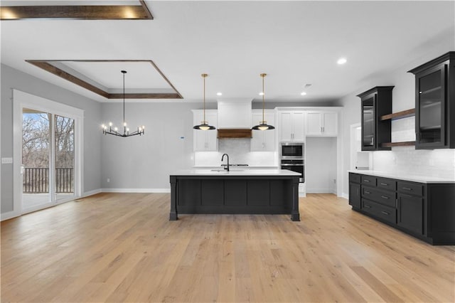 kitchen featuring open shelves, appliances with stainless steel finishes, light countertops, and a raised ceiling