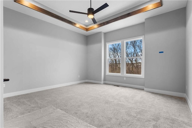 unfurnished room featuring recessed lighting, a raised ceiling, light carpet, ceiling fan, and baseboards