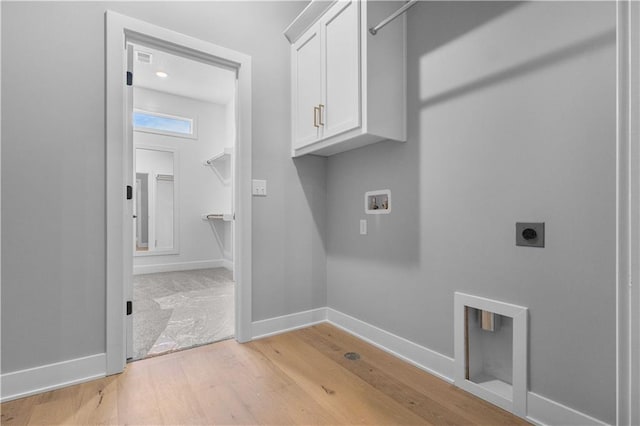 washroom with light wood-style flooring, hookup for an electric dryer, washer hookup, baseboards, and cabinet space