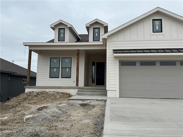 view of front of house with covered porch, an attached garage, and driveway