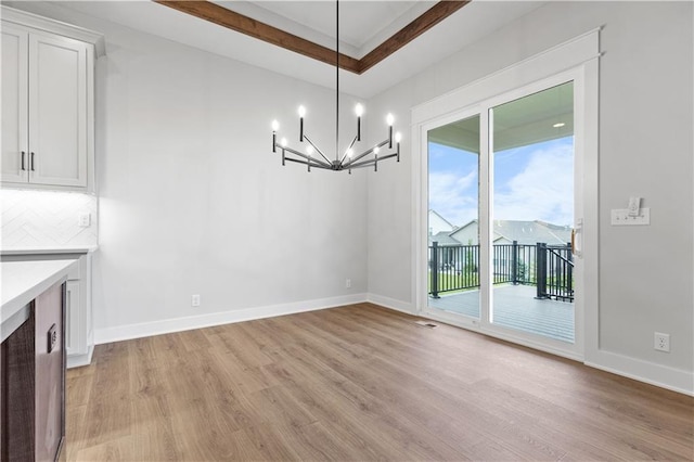 1617 SW Arbor Park Dr, Lees Summit, MO 64082 - unfurnished dining area with light wood-type flooring, a chandelier, and a tray ceiling