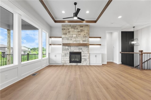 1617 SW Arbor Park Dr, Lees Summit, MO 64082 - unfurnished living room featuring a ceiling fan, light wood-style floors, recessed lighting, a stone fireplace, and a chandelier
