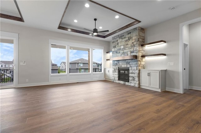1617 SW Arbor Park Dr, Lees Summit, MO 64082 - unfurnished living room featuring a tray ceiling, a ceiling fan, wood finished floors, a stone fireplace, and recessed lighting