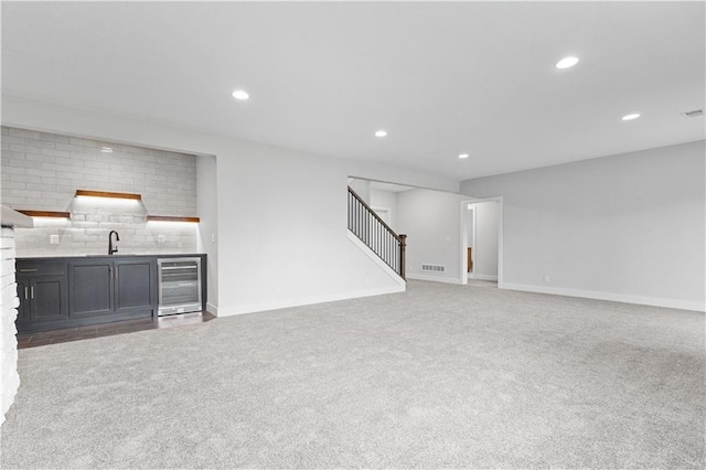 1617 SW Arbor Park Dr, Lees Summit, MO 64082 - unfurnished living room featuring wine cooler, wet bar, carpet flooring, stairs, and recessed lighting