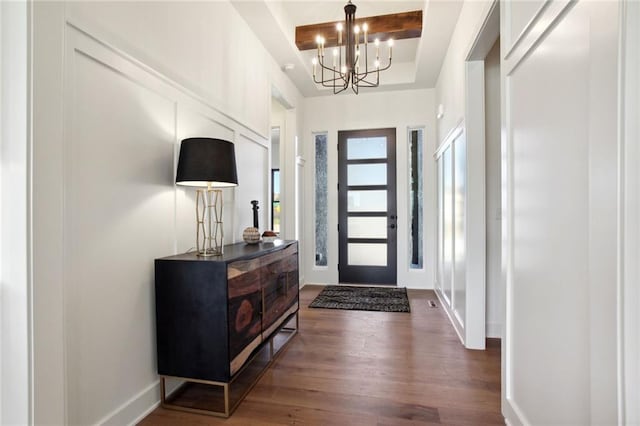 entryway with a notable chandelier and dark hardwood / wood-style floors