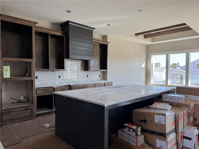 kitchen featuring tasteful backsplash, a textured ceiling, and a center island