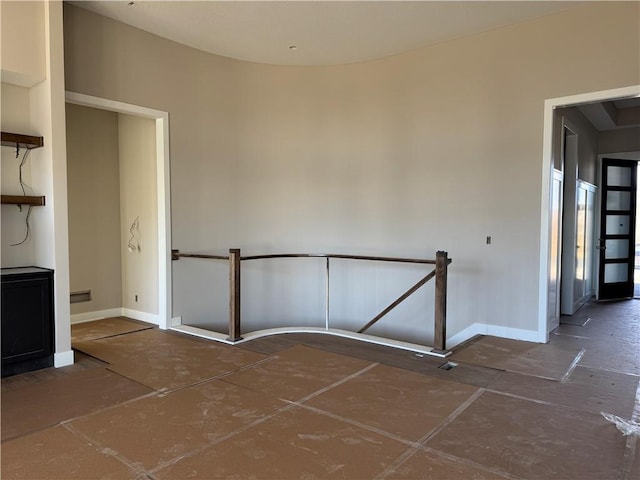 unfurnished room with baseboards