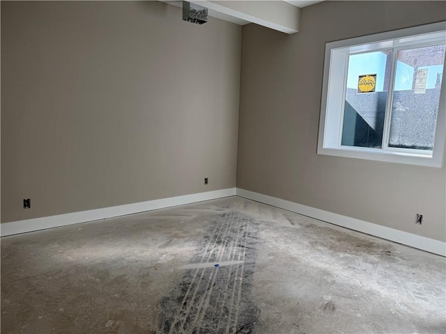 spare room with unfinished concrete floors and baseboards