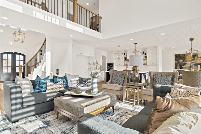 living room featuring a towering ceiling and light hardwood / wood-style floors