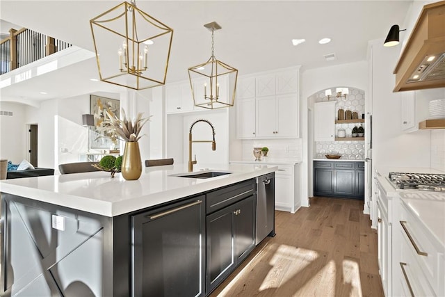 kitchen with pendant lighting, sink, an island with sink, white cabinetry, and stainless steel appliances