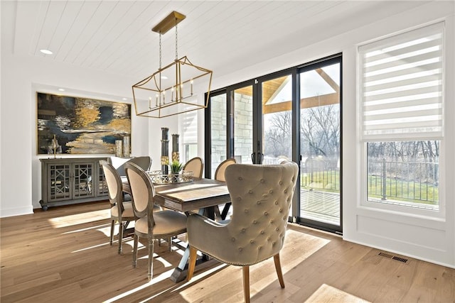 dining area featuring wood ceiling, hardwood / wood-style floors, and a notable chandelier