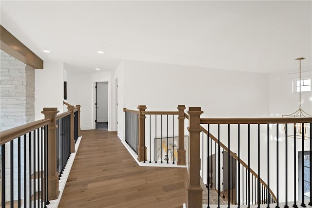 hallway with a chandelier and dark hardwood / wood-style floors