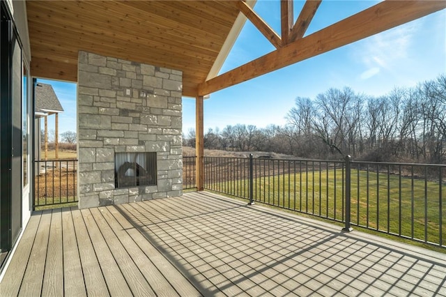 deck featuring a yard and an outdoor stone fireplace