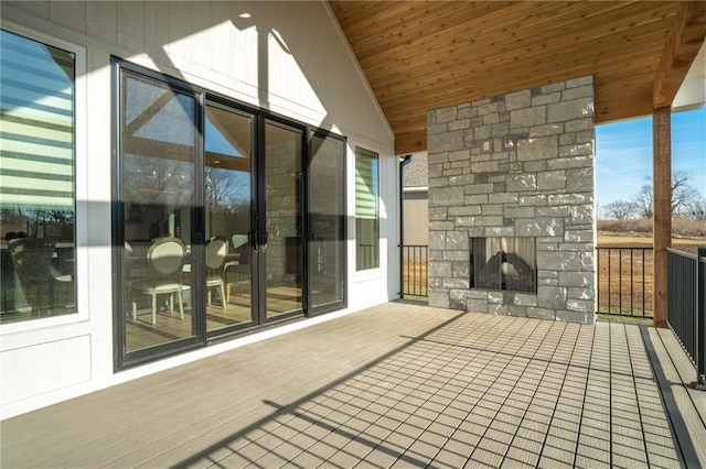 wooden deck featuring a patio and an outdoor stone fireplace