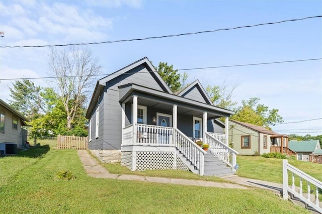 bungalow-style home featuring a front lawn, cooling unit, and covered porch