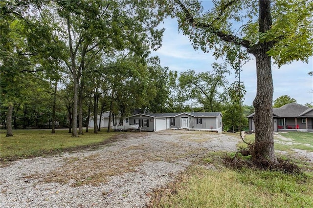 view of front of home with a garage, a front yard, and driveway