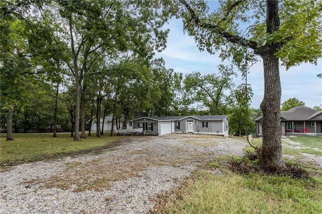 manufactured / mobile home featuring a front yard, driveway, and an attached garage