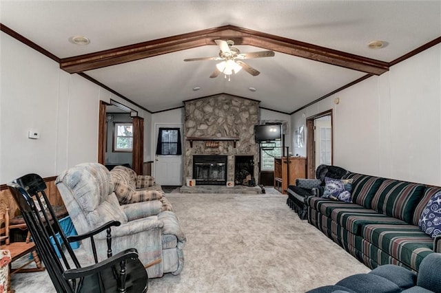 carpeted living room featuring vaulted ceiling with beams, a fireplace, ornamental molding, and ceiling fan