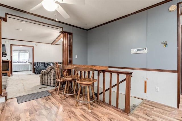 dining space with crown molding, ceiling fan, and wood finished floors