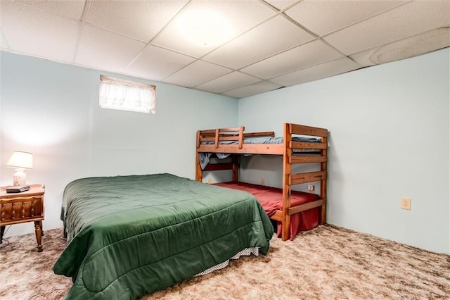 bedroom with a drop ceiling and carpet floors