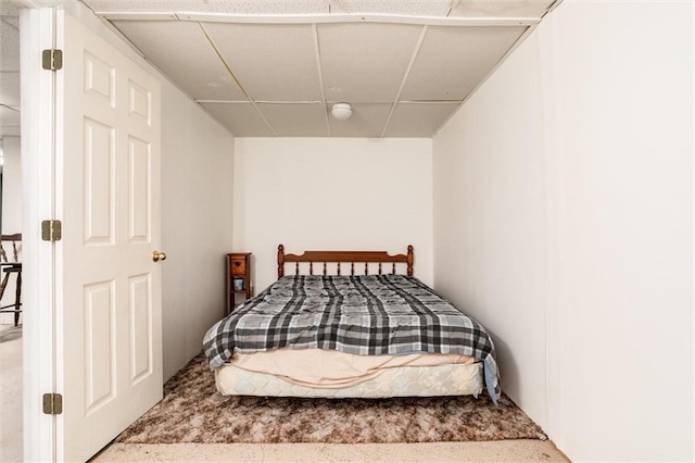 carpeted bedroom featuring a drop ceiling