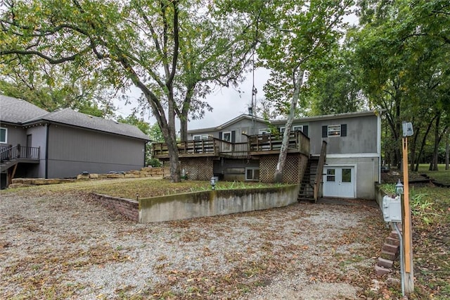 rear view of property featuring a deck and stairway