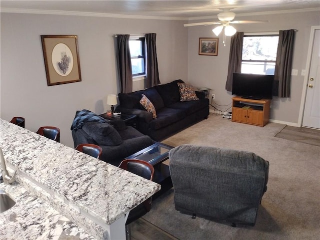 living room with ceiling fan, ornamental molding, and light carpet