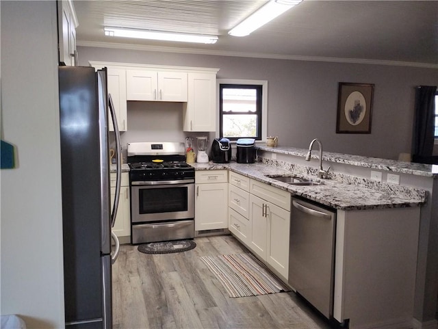 kitchen featuring white cabinetry, appliances with stainless steel finishes, kitchen peninsula, and light stone counters