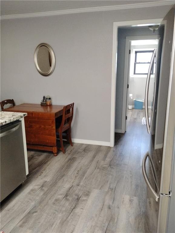 kitchen featuring light hardwood / wood-style floors, appliances with stainless steel finishes, and crown molding