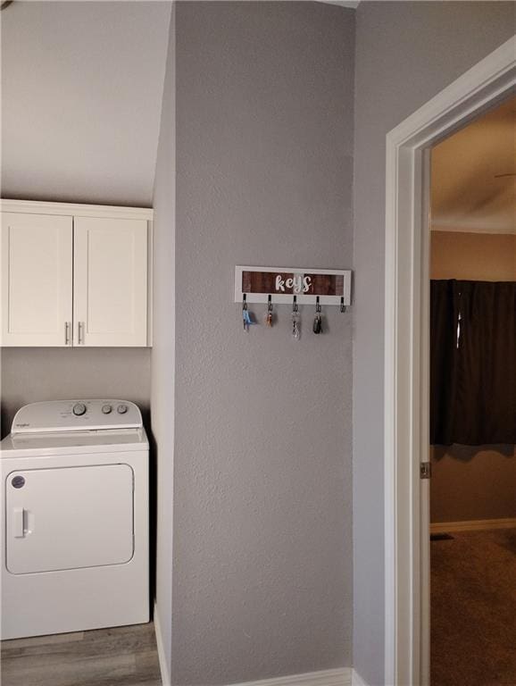 clothes washing area with cabinets and washer / dryer