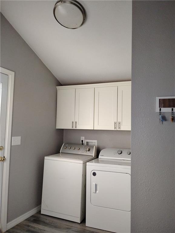 laundry room with cabinets, separate washer and dryer, and dark wood-type flooring