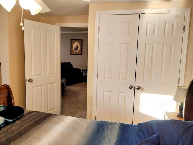 bedroom with ceiling fan, carpet, and a closet