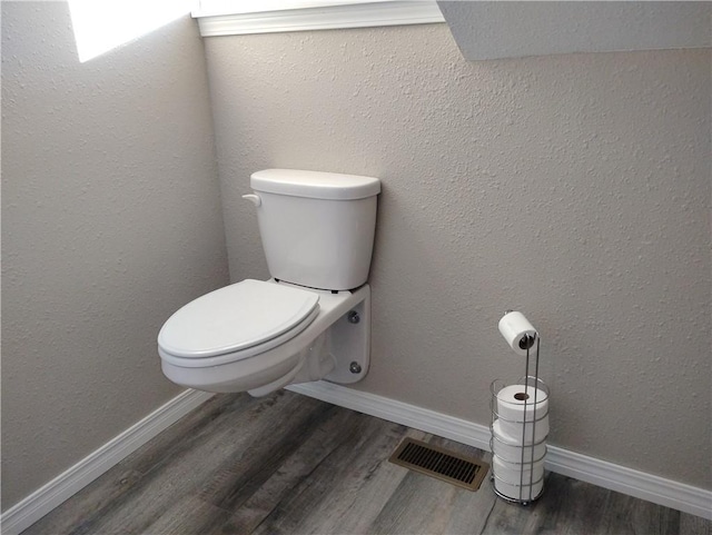 bathroom featuring toilet and wood-type flooring